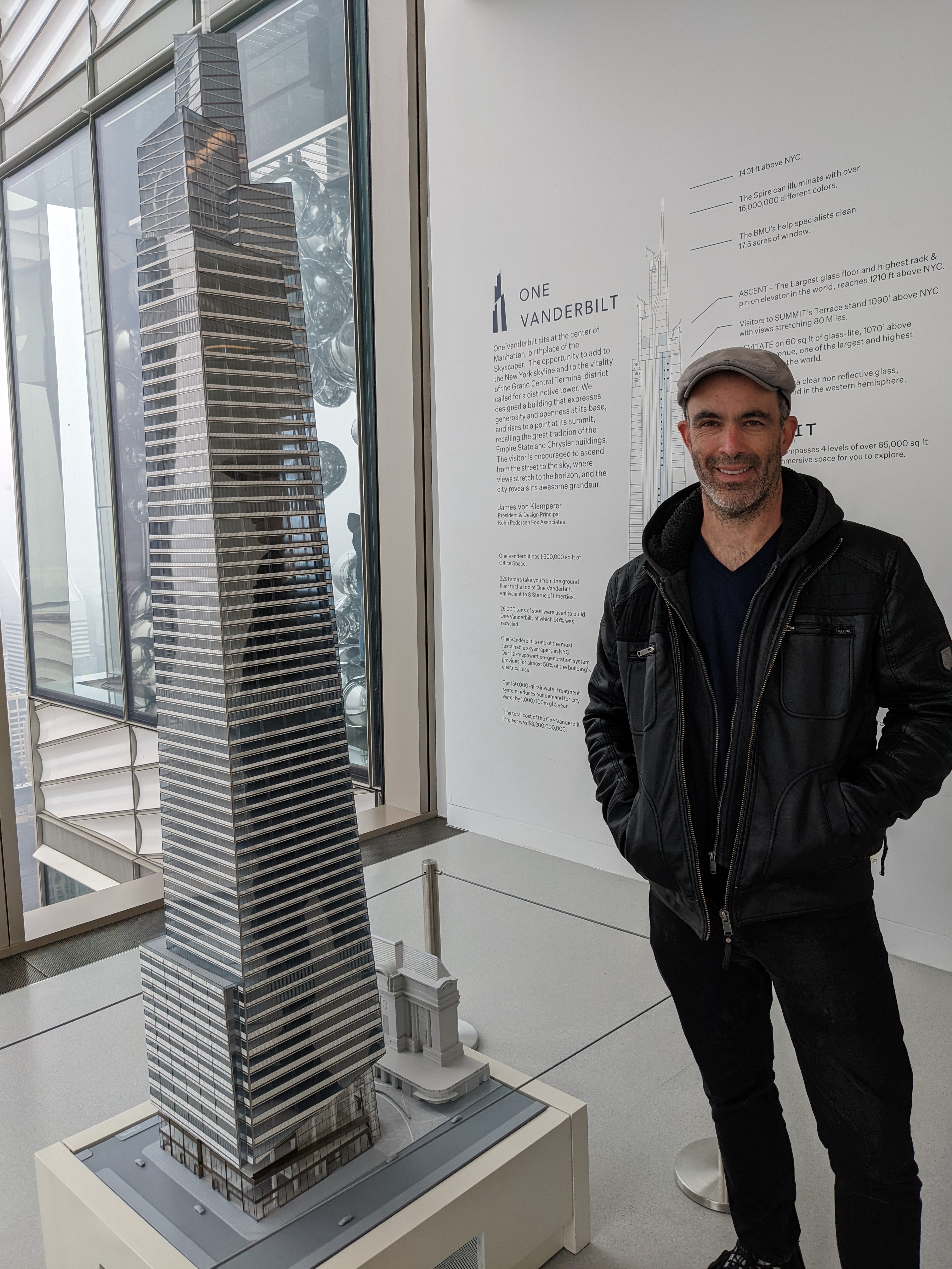 Ari standing next to a model of One Vanderbilt